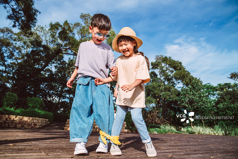 一步步：兄弟姐妹在公园玩耍图片素材