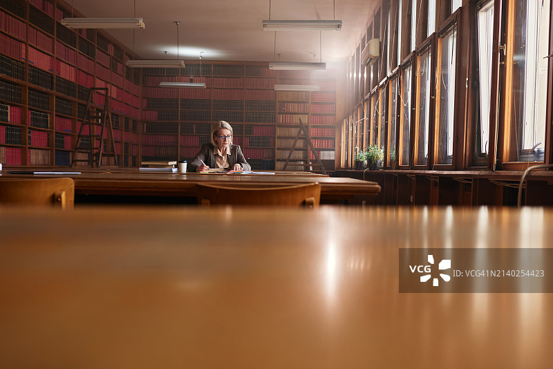 年长的女律师在图书馆查阅资料图片素材