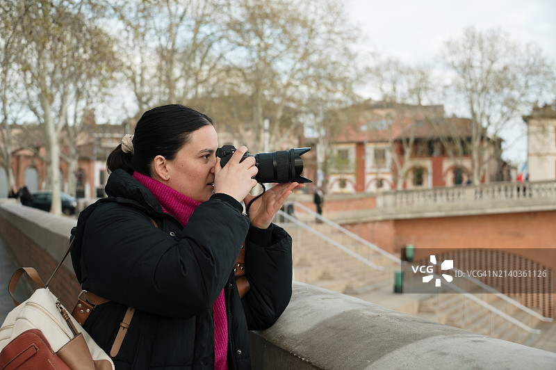 年轻女人用单反相机拍照图片素材