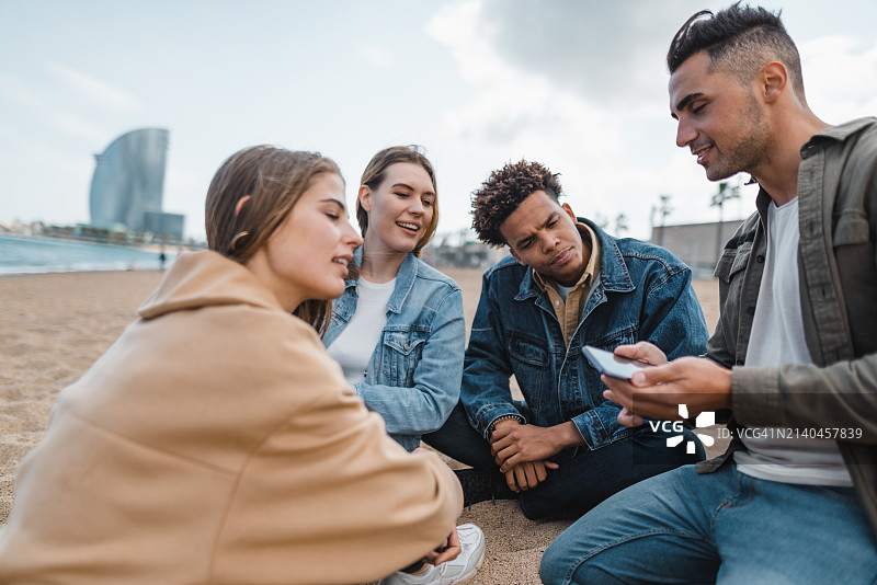 朋友们在海滩上一起聊天图片素材