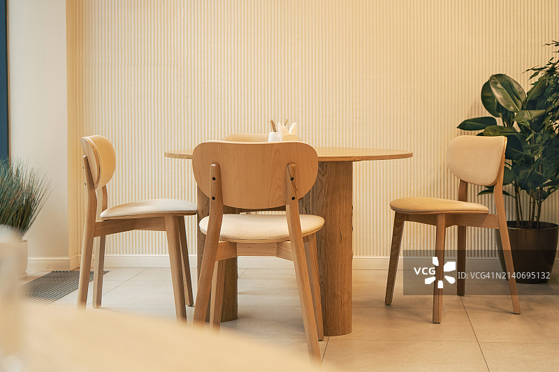 明亮简约室内设计空间中的现代木制餐具：咖啡馆里的桌椅图片素材