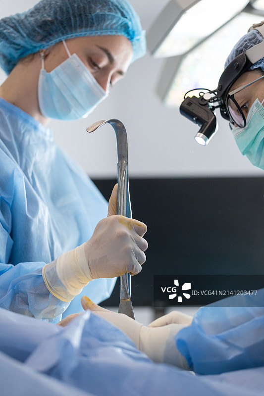 整形外科医生和手术室护士为一名女性做隆胸手术图片素材