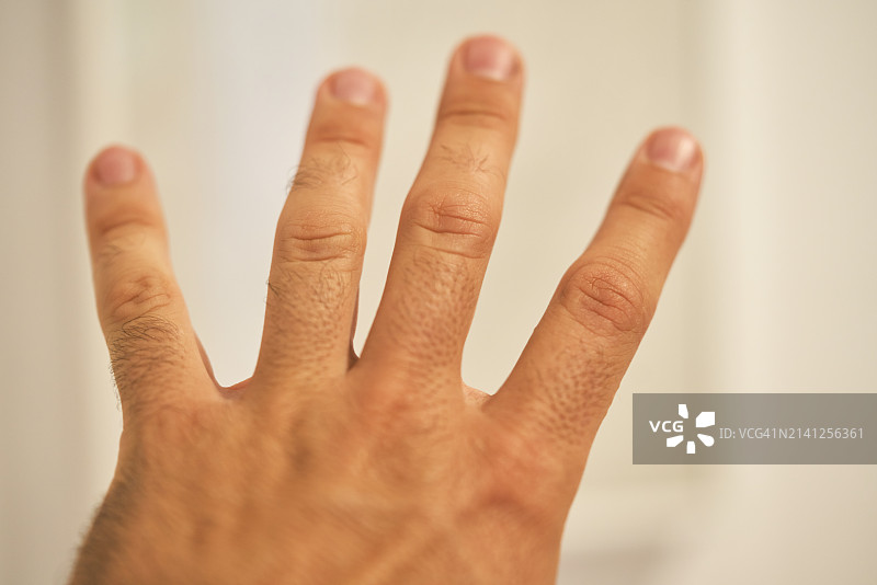 男人用手指在室内比出数字四的形状图片素材