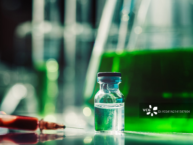 实验室中的绿色液体试管烧瓶和红色注射器图片素材