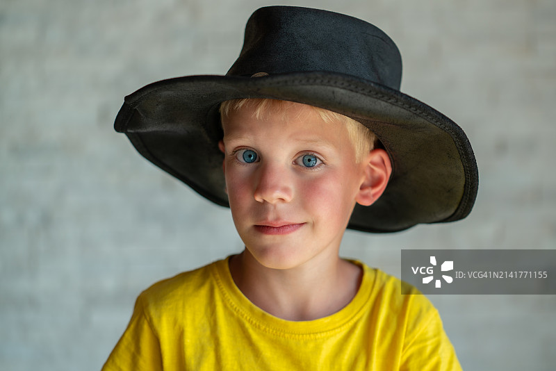 戴帽子的靠墙男孩肖像图片素材