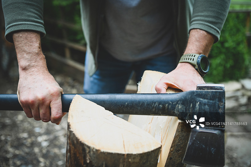 在院子里砍木头的中年男子图片素材