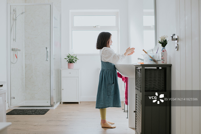 孩子在家里浴室的水槽边洗手图片素材