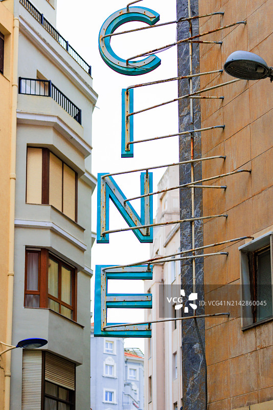 狭窄街道建筑上的城市电影院标志图片素材