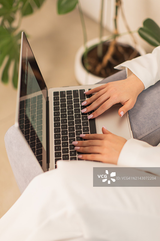 穿白色商务套装使用笔记本电脑的金发女子图片素材