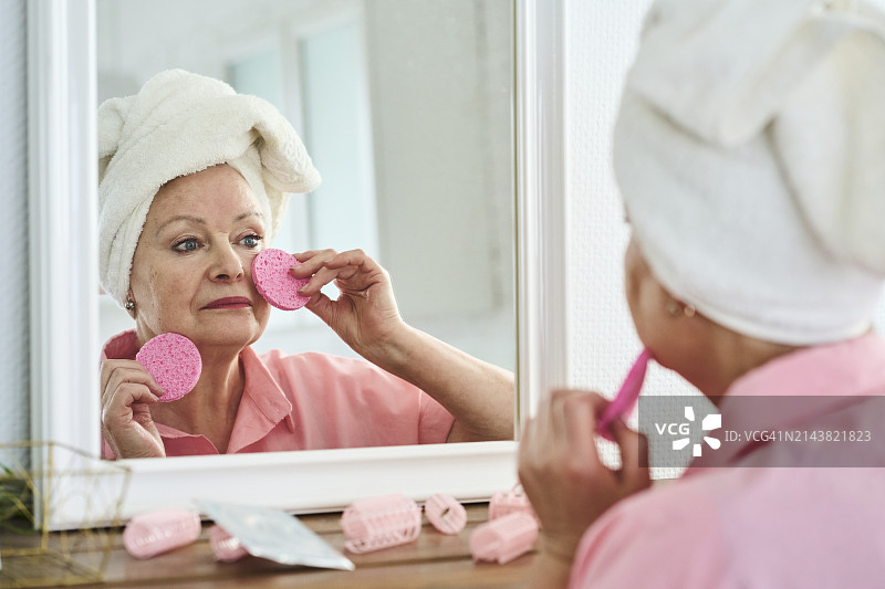 在家照镜子护肤的裹着毛巾的女人图片素材