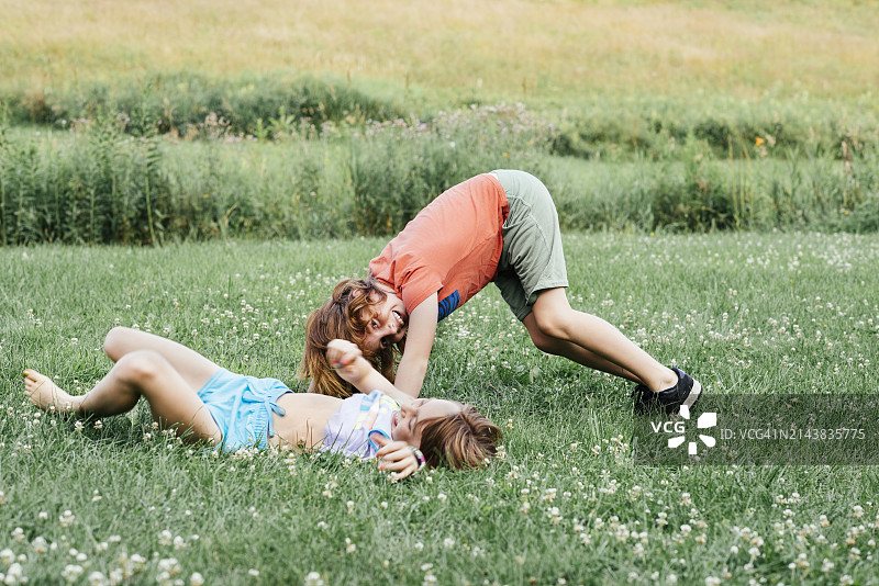 兄妹俩在草地上玩耍图片素材