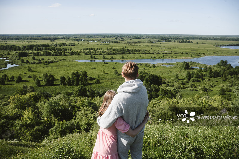 父女拥抱并看着草地图片素材