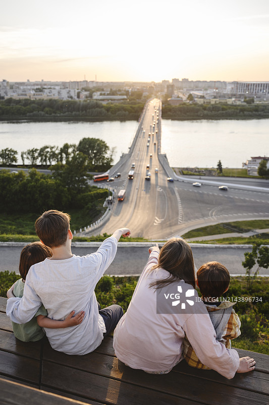 姐弟或兄妹坐在长凳上观看伏尔加河图片素材