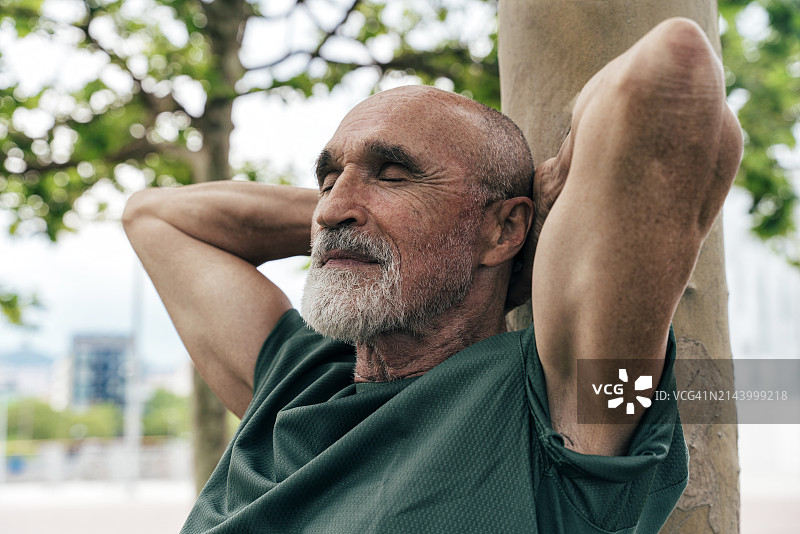 退休老人靠在树干上闭着眼睛图片素材