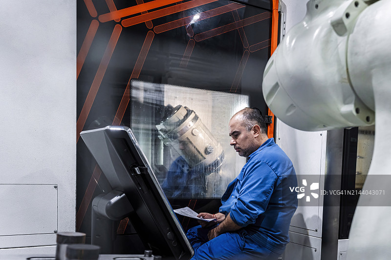 在工业中操作数控机床的技术员图片素材
