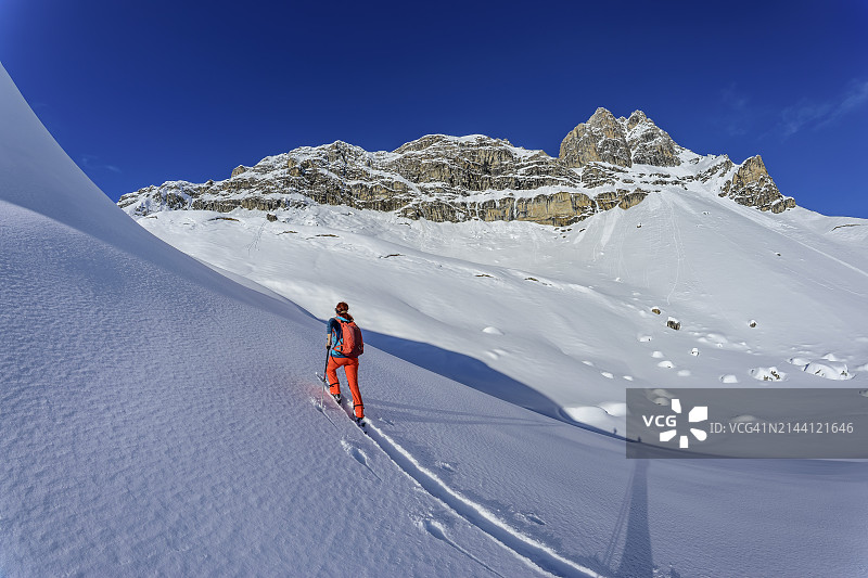 在奥地利蒂罗尔州图克斯阿尔卑斯山的云霄峰上滑雪的背包女性图片素材