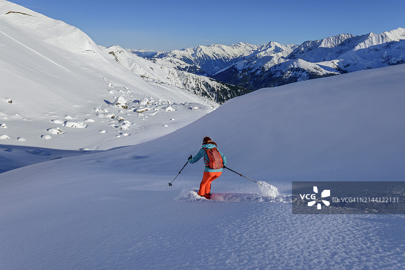 女人在琼斯约赫山背部滑雪下坡，背景是齐勒塔尔阿尔卑斯山，图克斯阿尔卑斯山，蒂罗尔，奥地利图片素材