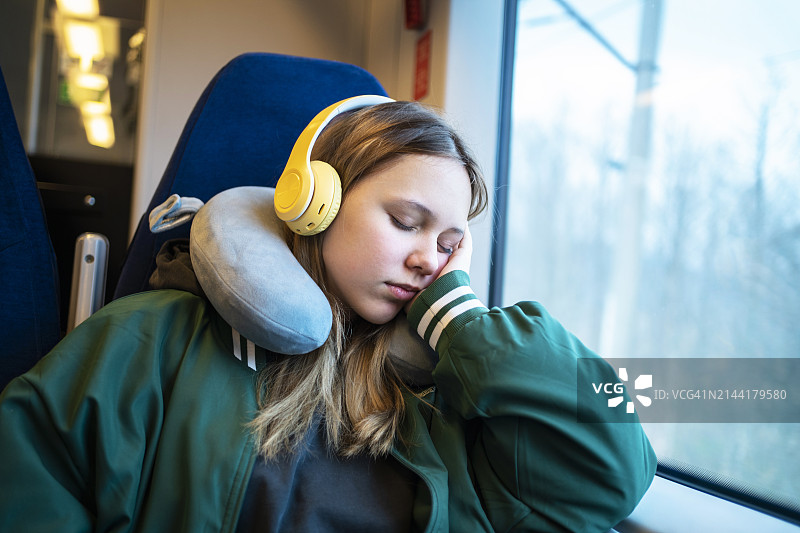 在火车上小睡的疲惫金发女孩图片素材
