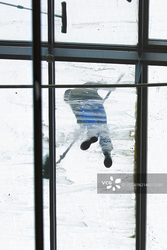 玻璃天花板上清洁工的仰视图图片素材