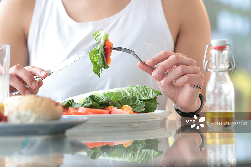 混合种族女人吃沙拉的特写图片素材