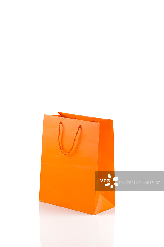 白色背景上的橙色纸质购物袋，对角线角度图片素材