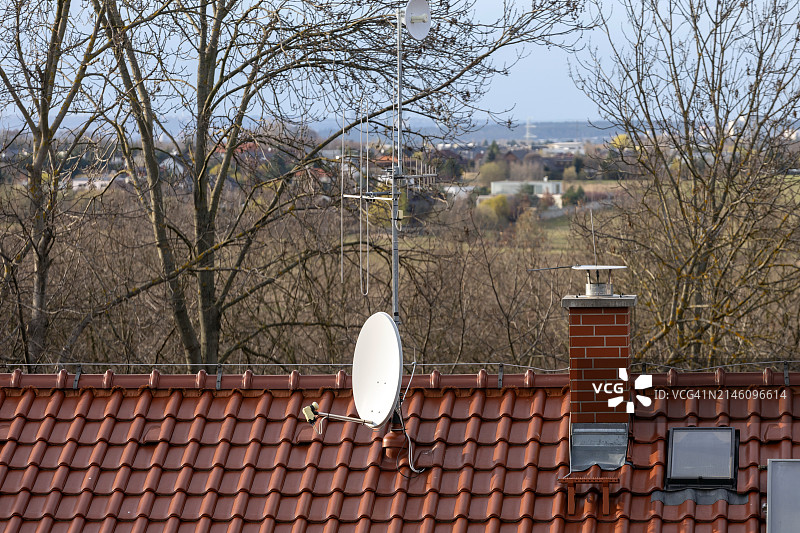 屋顶上的卫星天线和裸树景观图片素材