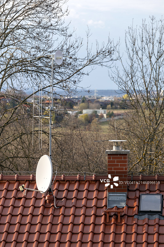 屋顶上的卫星天线和裸树景观图片素材
