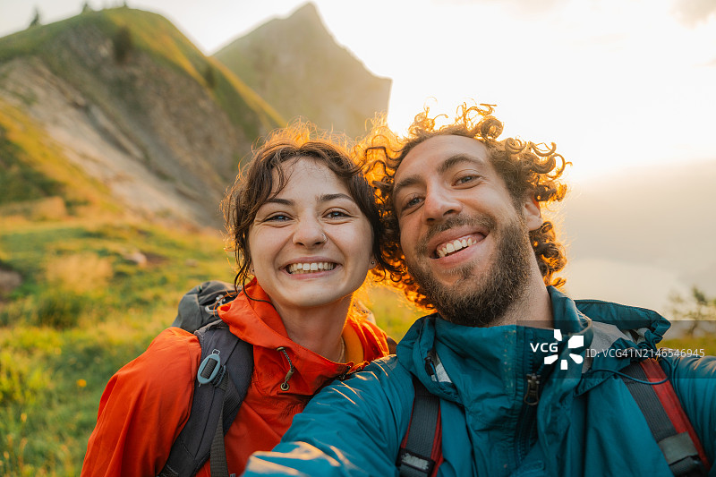 情侣在夏季瑞士阿尔卑斯山一起徒步旅行的自拍照图片素材
