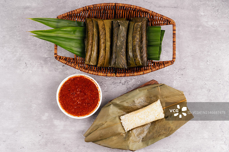 俯视角度拍摄的椰浆糯米卷或用树叶包裹的糯米和花生酱图片素材