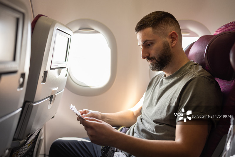 男人在飞机上查看机票图片素材
