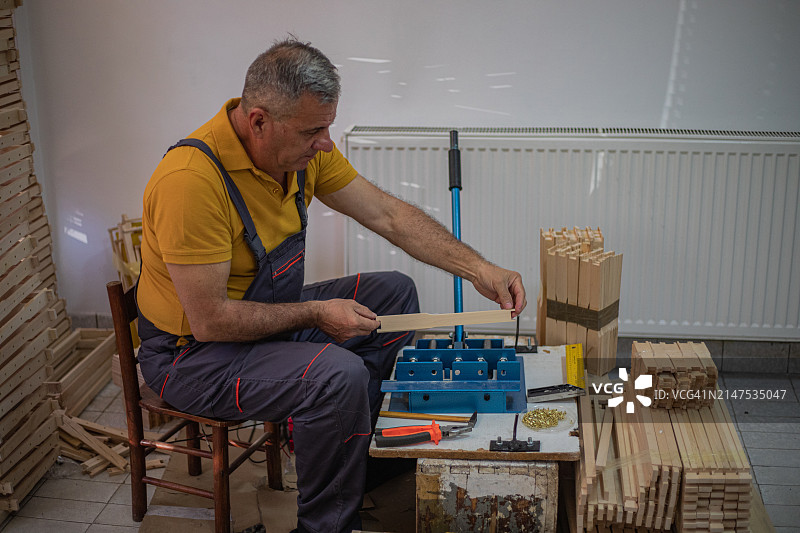 老年男人为蜂箱准备蜂巢框架图片素材