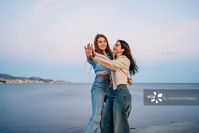 在西班牙马拉加码头跳舞的两位女性朋友图片素材