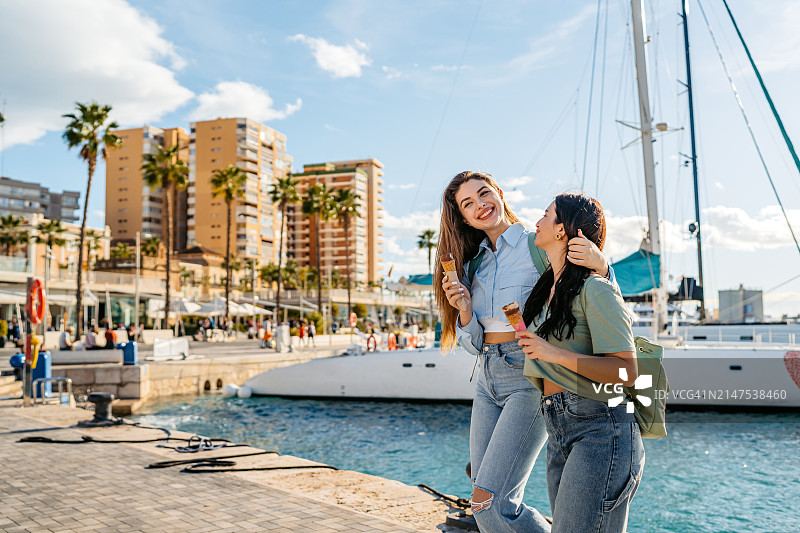 两位女性朋友在西班牙马拉加码头吃冰淇淋图片素材