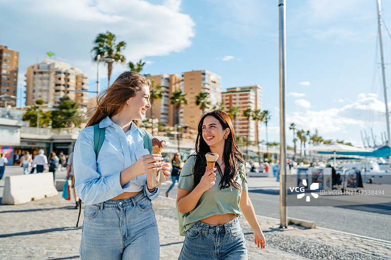 两位女性朋友在西班牙马拉加码头吃冰淇淋图片素材