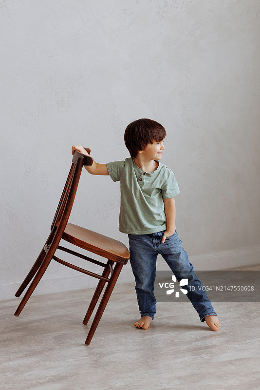 坐在木椅上的简约风格小男孩图片素材