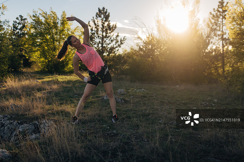 在山间跑步前拉伸的女人图片素材