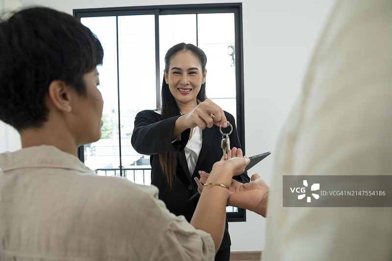 房地产经纪人将钥匙交给夫妇图片素材