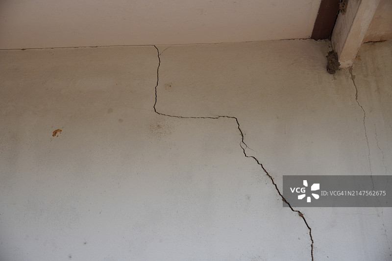 水泥墙上的裂缝，裸露的抛光灰色和光滑的表面纹理混凝土材料复古背景细节建筑施工砖墙抹灰和油漆图片素材