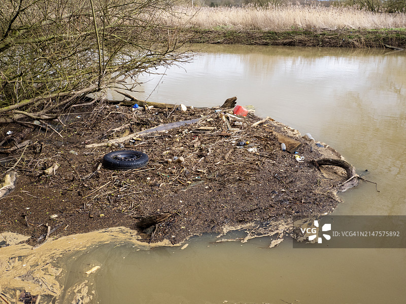 英国莱斯特郡罗斯利附近的索尔河洪水过后，树上挂着塑料垃圾图片素材