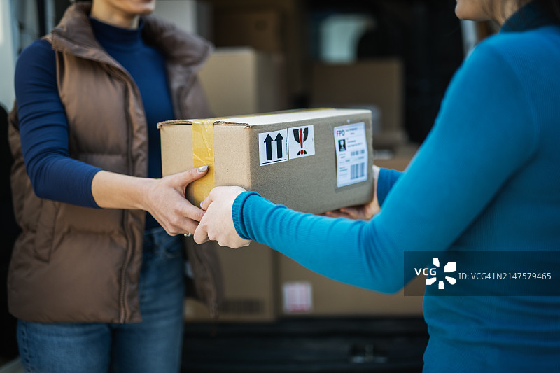 女送货员向顾客派送包裹图片素材
