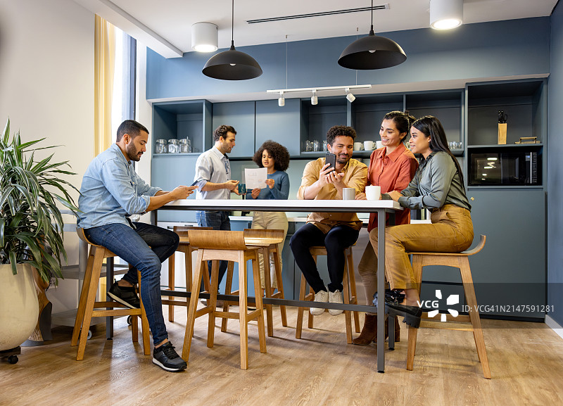 在办公室休息并在自助餐厅分享的商人们图片素材
