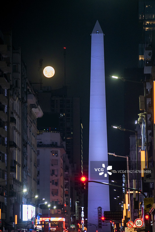 夜晚的方尖碑和满月，阿根廷布宜诺斯艾利斯科连特斯大道图片素材
