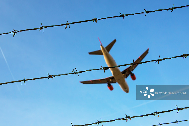 蓝天下带客机的铁丝网图片素材