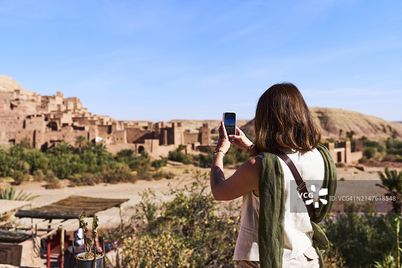 摩洛哥建筑外站立拍照的女游客背影图片素材