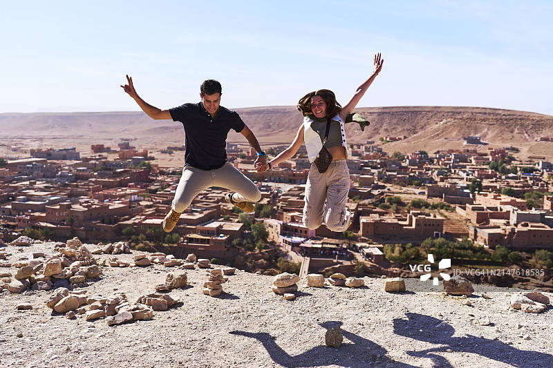 在摩洛哥沙漠建筑中微笑的年轻夫妇肖像图片素材