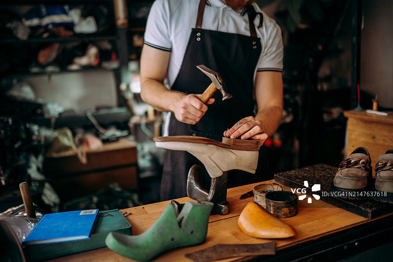 微笑的年轻鞋匠肖像图片素材