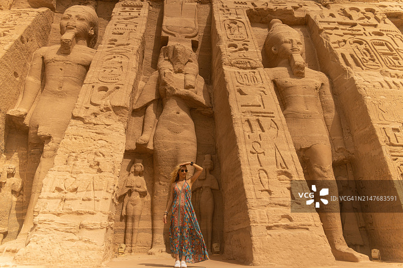 女人站在埃及阿布辛贝的哈托尔神庙和尼菲尔塔利神庙前图片素材