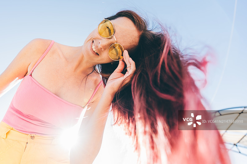 长长的粉色头发在空中飞舞的年轻女子肖像图片素材
