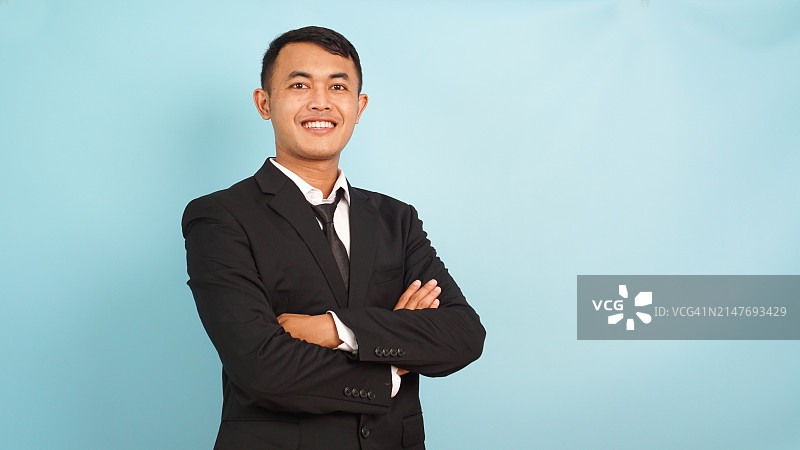 穿着黑色西装，自信而积极的年轻商务男士图片素材