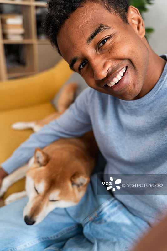 在家中与柴犬在一起的微笑男人图片素材